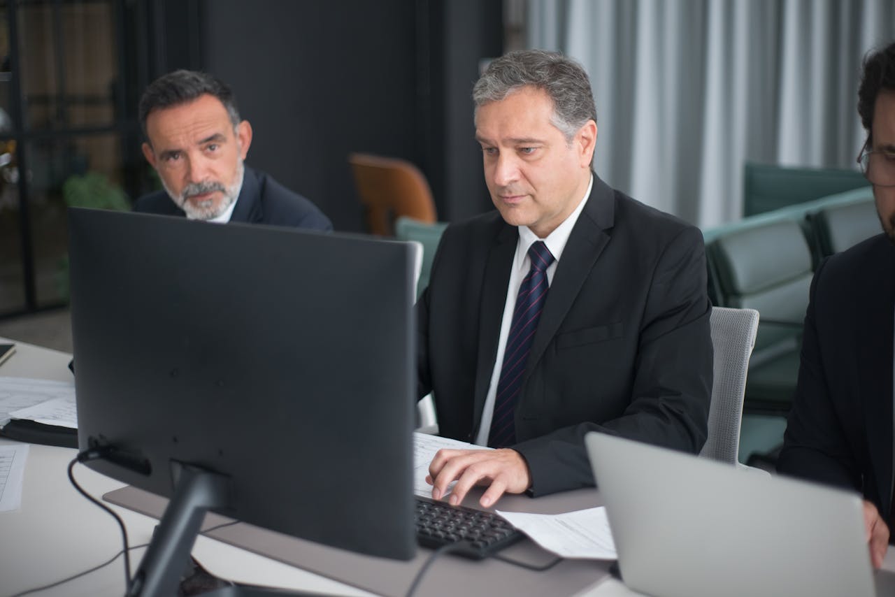 Home Professionals in a modern office engaged in a business meeting with computers.